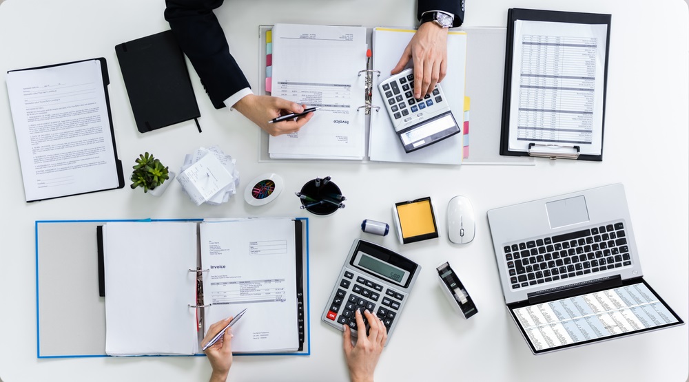 Finance professionals working on desks with laptops and documents